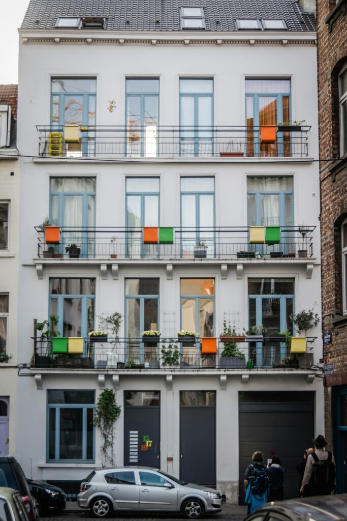 pexels-photo-1772198-1772198 Charming facade of a city apartment building with colorful balconies and windows.